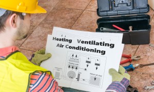 Repairman is looking at documentation of HVAC (Heating, Ventilating, Air Conditioning).