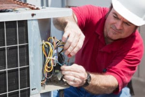 trained tech performing air conditioner repair
