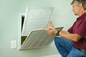 man switching the air filter of his home's ac unit