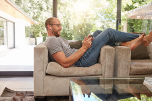 man relaxing at home in living room on couch