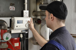 a heater repairs technician setting the thermostat
