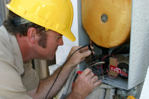 An air conditioning repairman testing a heat recovery unit.