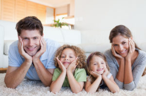family laying on carpet of their living room